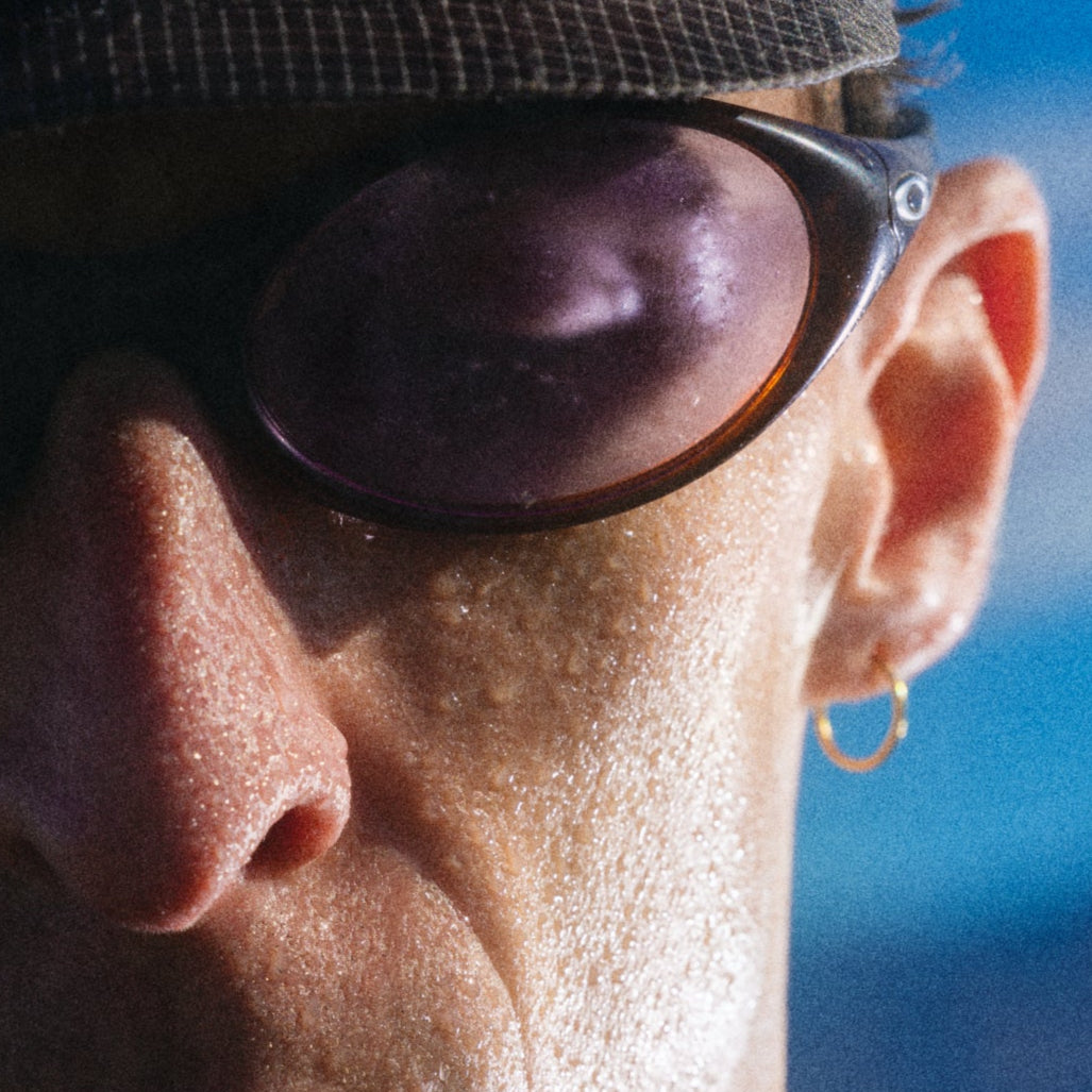 Close-up of a person wearing sunglasses with a blue sky background